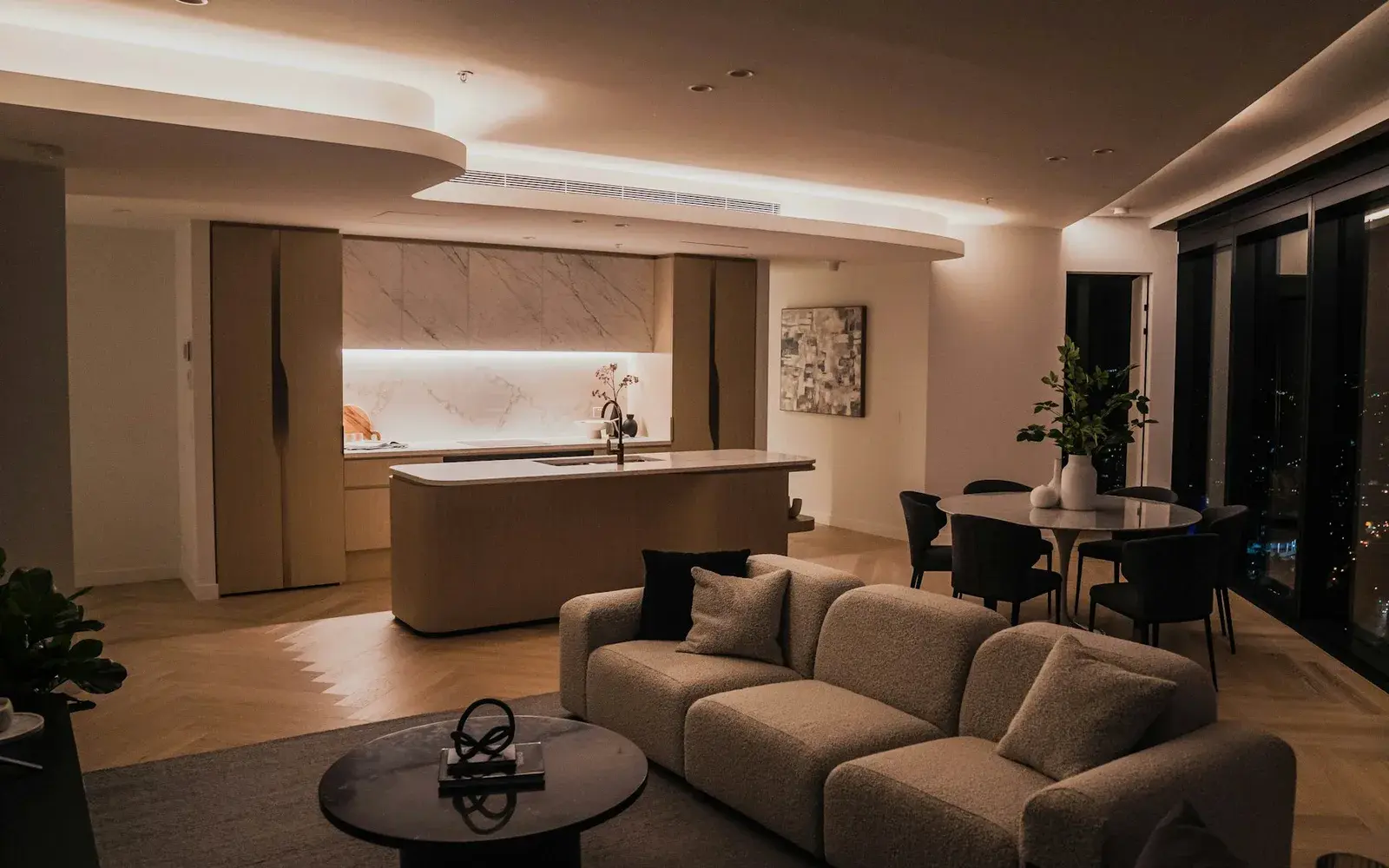 Warmly lit open plan living room with a cove lit false ceiling, by Nestora Interiors, interior designer in Hyderabad